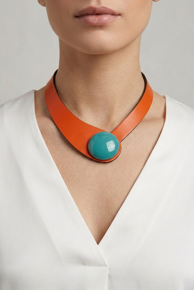 Collar de cuero naranja con botón cerámico turquesa sobre modelo