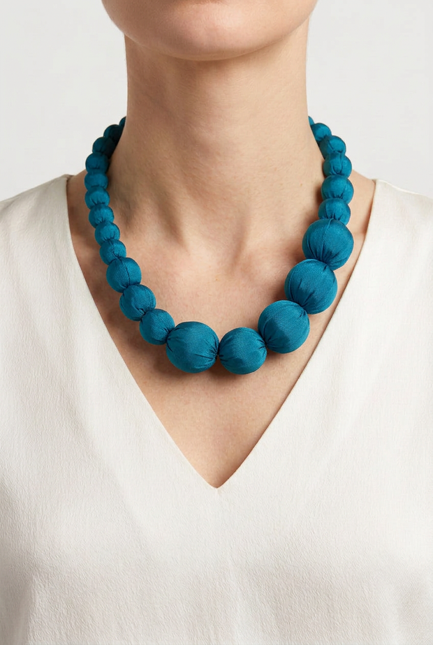 Collar Seda Lonh petróleo sobre modelo con camiseta blanca