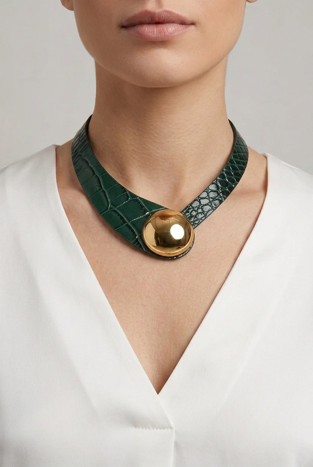Collar de cuero verde botella con textura de cocodrilo y botón dorado sobre modelo
