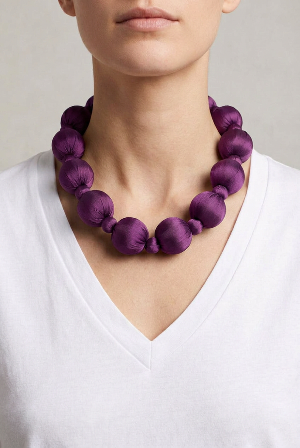 Collar Seda Linh morado sobre modelo con camiseta blanca