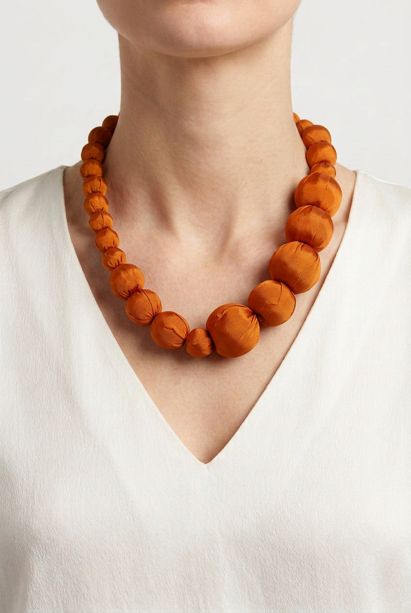 Collar Seda Lonh naranja sobre modelo con camiseta blanca