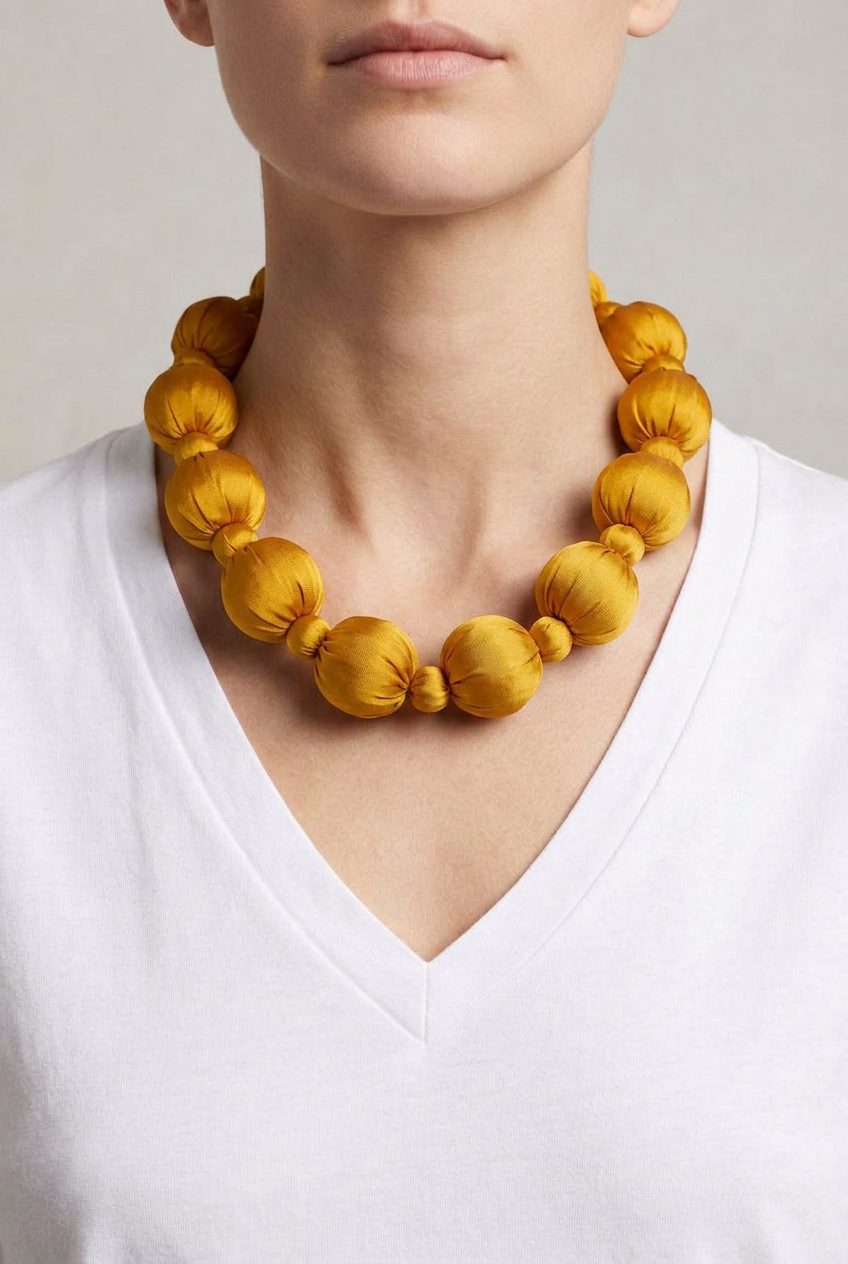 Collar Seda Linh amarillo sobre modelo con camiseta blanca