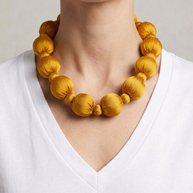 Collar Seda Linh amarillo sobre modelo con camiseta blanca