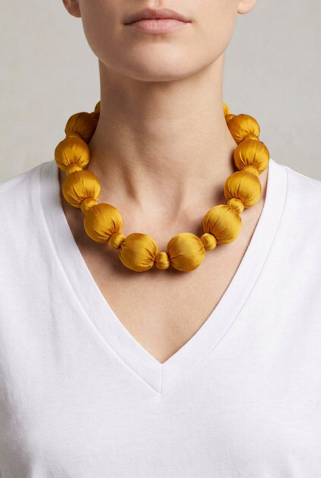Collar Seda Linh amarillo sobre modelo con camiseta blanca