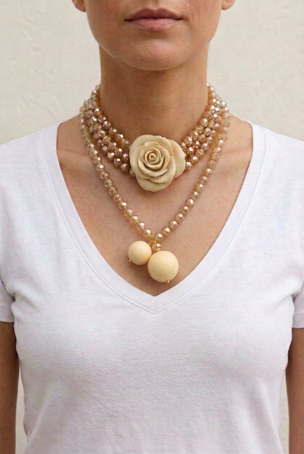 Collar Camelia marfil largo sobre modelo con cristales facetados y bolas opacas de distinto tamaño por encima del escote