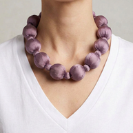 Collar Seda Linh malva sobre modelo con camiseta blanca