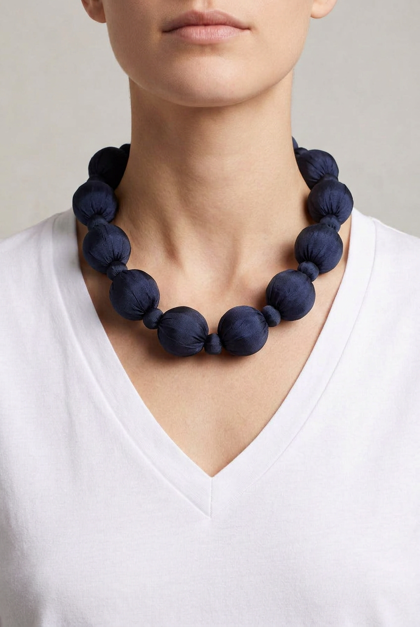 Collar Seda Linh marino sobre modelo con camiseta blanca