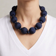 Collar Seda Linh marino sobre modelo con camiseta blanca