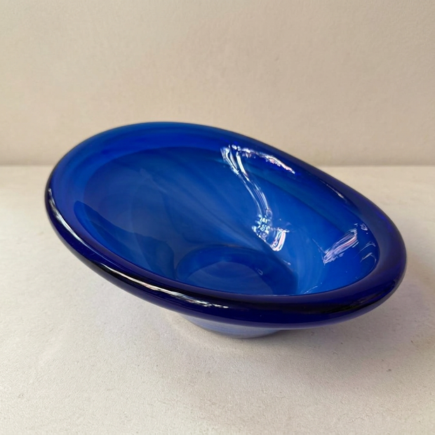 Cuenco de cristal sueco azul, vista inclinada original con base de piedra clara y pared beige