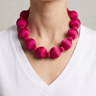Collar Seda Linh rosa sobre modelo con camiseta blanca