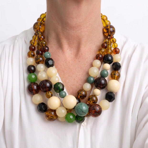 Collar de varias vueltas multicolor ajustado al cuello sobre modelo con blusa blanca
