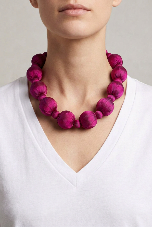 Collar Seda Linh fucsia sobre modelo con camiseta blanca